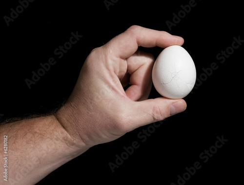 hand holds an egg with cracks The concept of destruction.