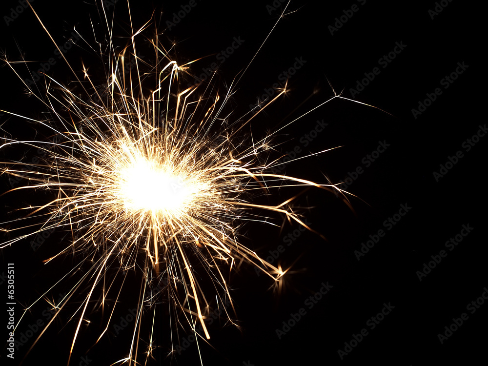 Details of a burning handheld firework over black background