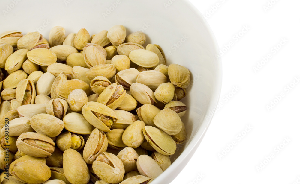 bowl of pistachios close-up over white bowl of pistachios close-up over white