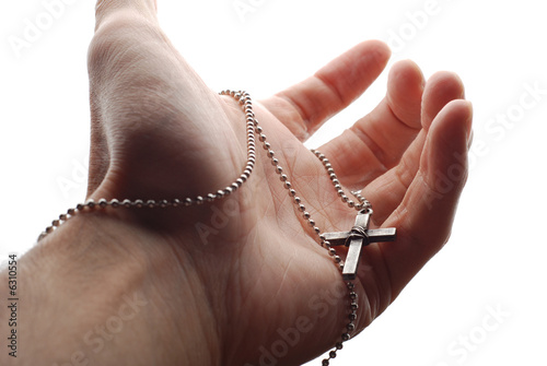 a hand is holding the cross in its palm