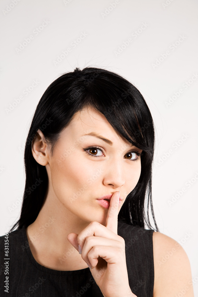 A businesswoman with her finger on her lips A businesswoman with her finger on her lips