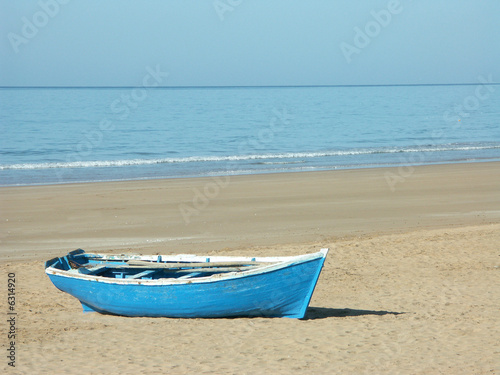 Foto Une barque bleue de pêcheur échouée sur une plage