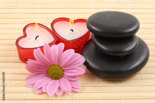 stack of pebbles with candles and flower - aromatherapy