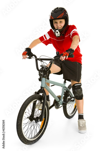 Happy boy in helmet on BMX and looking at camera