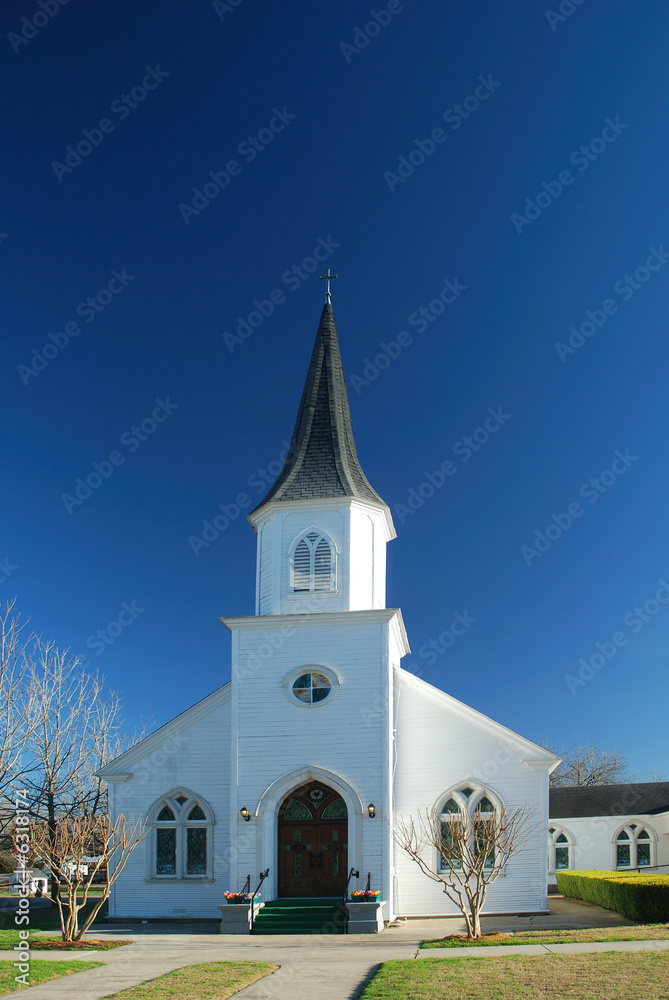 Community church is pristine white against a dark blue sky.