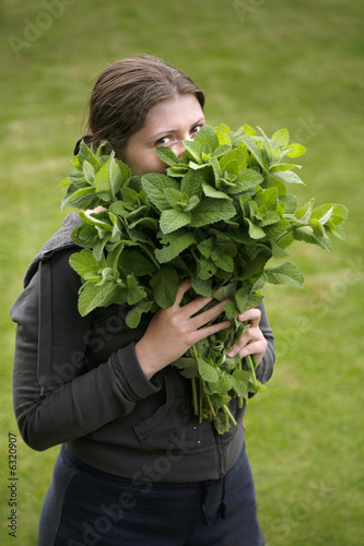 happy girl with fresh spearmint bouquet in hands