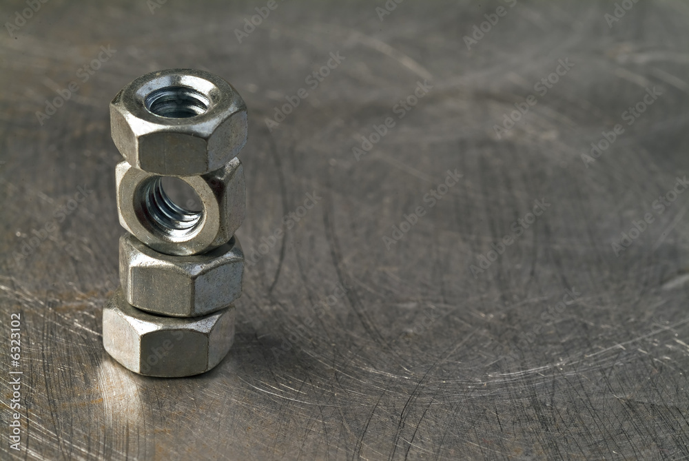 tower of balanced nuts on metallic background tower of balanced nuts on metallic background
