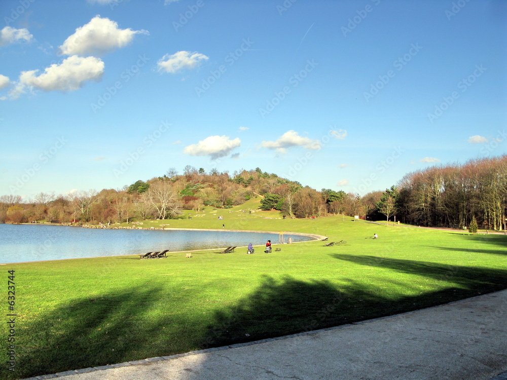 Petit lac avec colline, ciel bleu et nuages blancs Petit lac avec colline, ciel bleu et nuages blancs