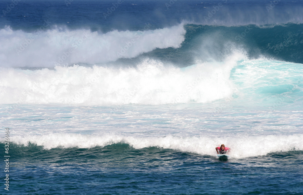 Teenage tourist on surfboard in big waves,  Maui, Hawaii
