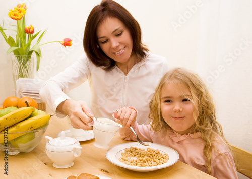 Mother and her daughter have a breakfast  