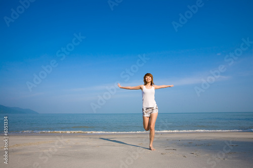 woman on one leg by the beach
