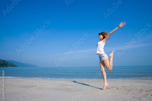 woman jumping and having fun by the beach