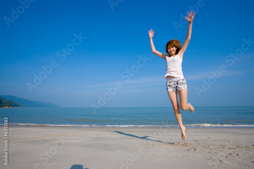 woman jumping and having fun by the beach