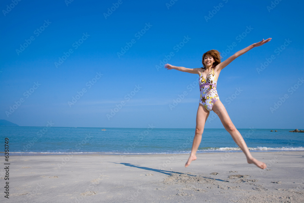 woman jumping happily by the beach woman jumping happily by the beach