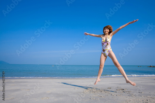 woman jumping happily by the beach