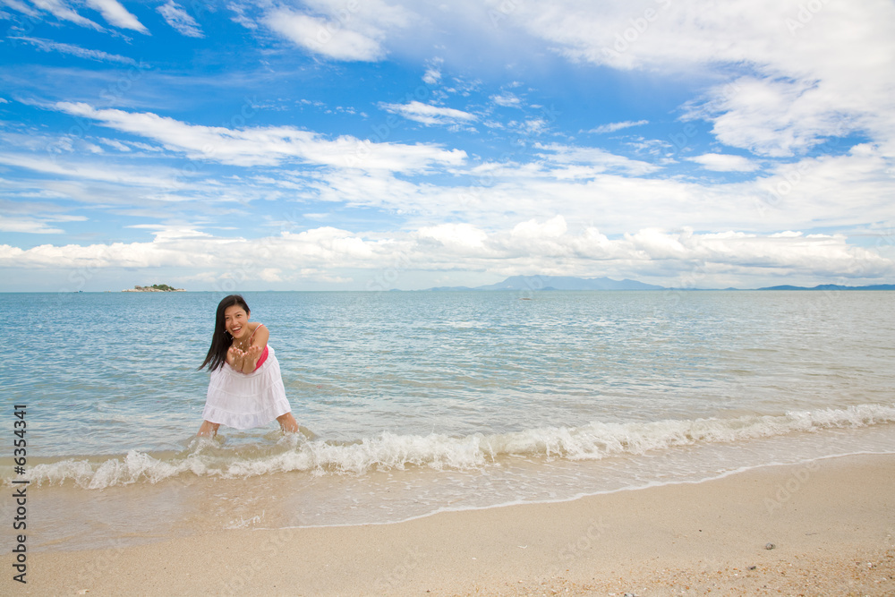 woman having fun splashing  in the sea by the beach