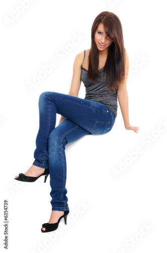 sexy girl in jeans sitting on the white table