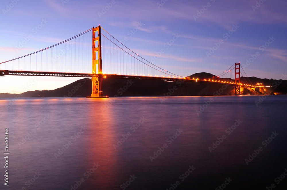 Glowing Golden Gate Bridge at sunset. Shot from Fort Point area.