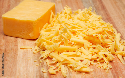 Grated mature cheddar cheese on wooden board