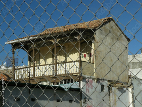 Casa con balcon a traves del cercado