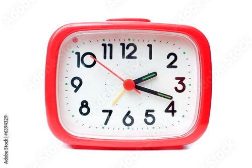 Old red alarm clock on a white background