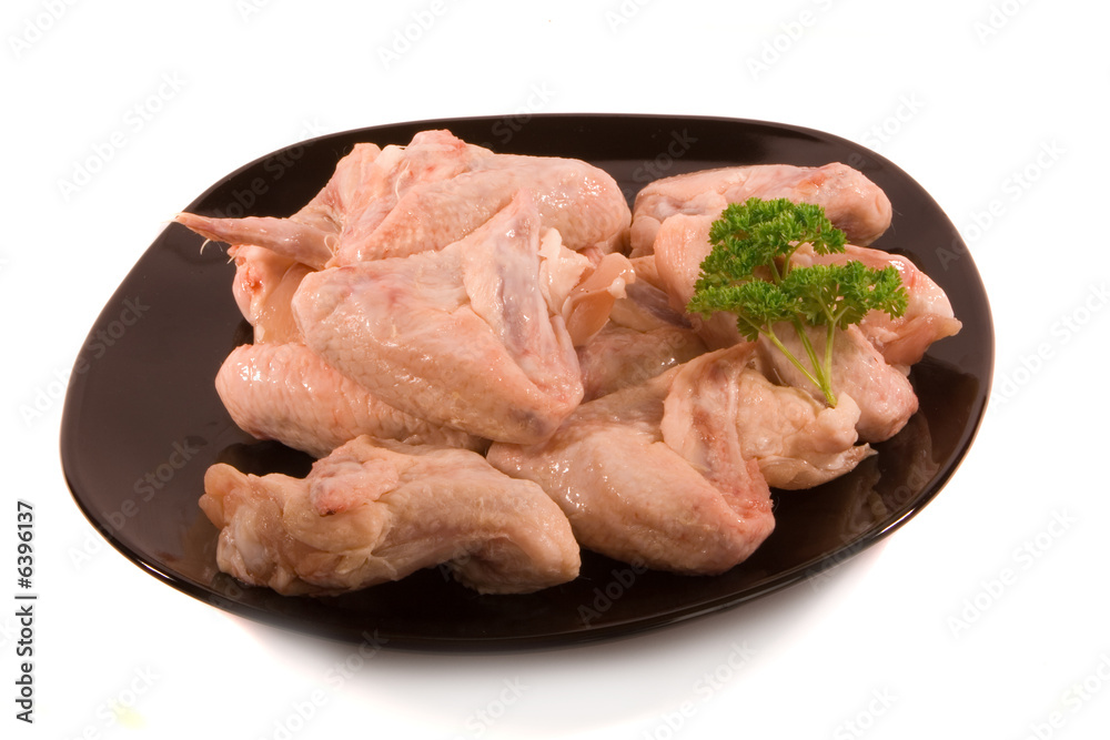 Pile of Chicken Wings on Black Plate ready for Cooking Pile of Chicken Wings on Black Plate ready for Cooking