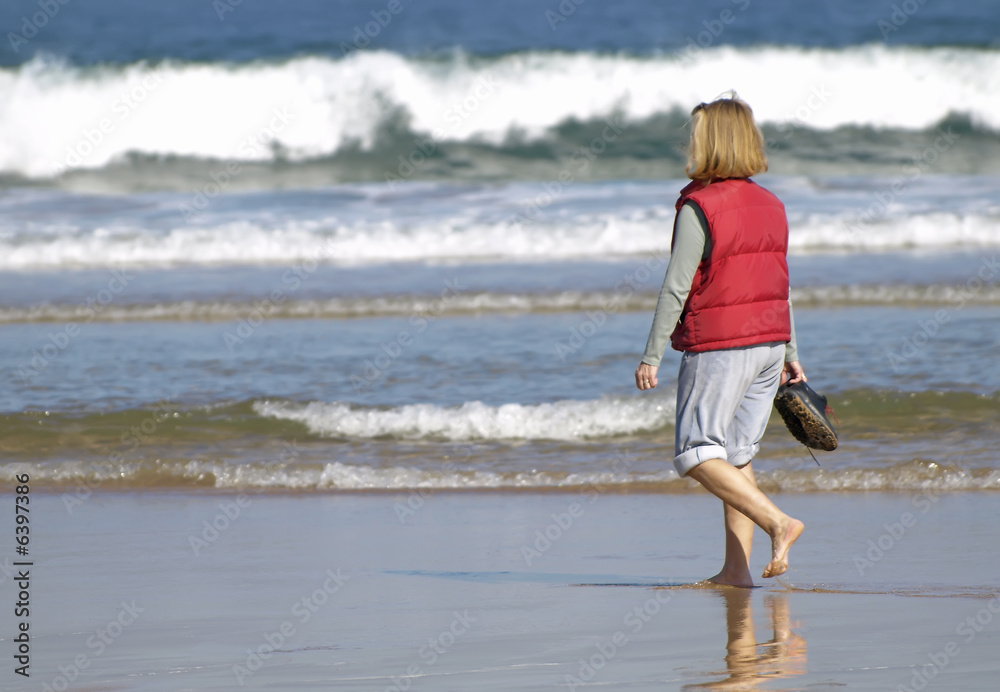 Mujer paseando por la orilla de la playa