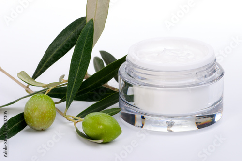 ar of moisturizing face cream and twig with green olives..