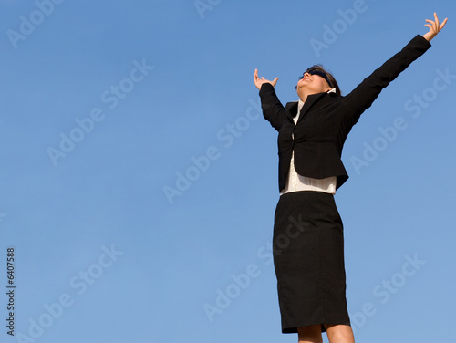 successful young business woman arms raised