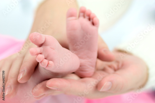 Mother's hands holding Baby's tiny feet © Olga Sapegina