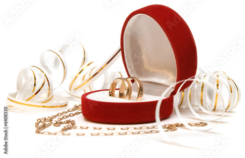 Close up of wedding bands and gold chain looking like heart 