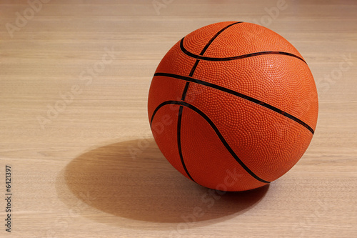Photo of one basket ball in a wooden floor