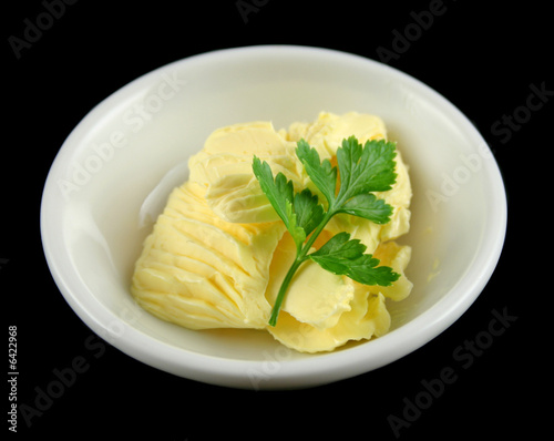 Fresh butter sculpted with parsley in a dish.