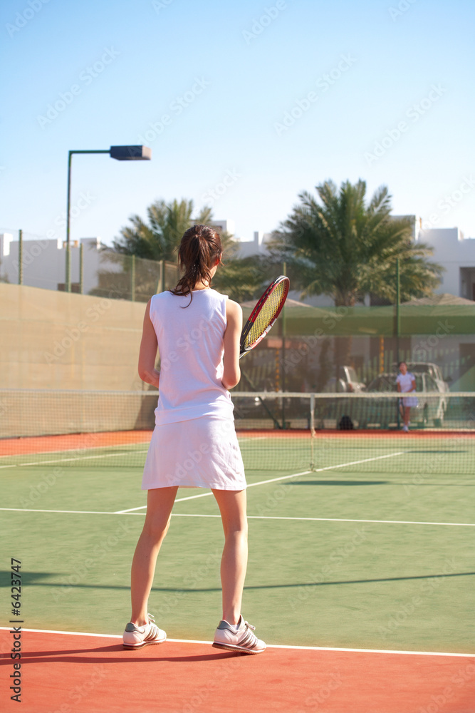 Young women playing tennis in the sun