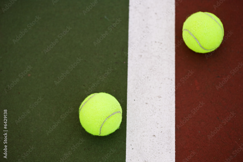 A shot of two tennis balls on a tennis court