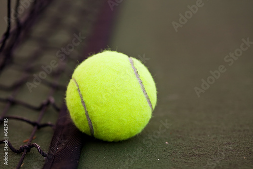 A shot of a tennis ball and a net on a tennis court © arekmalang