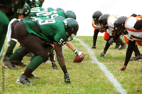 Football players ready to snap the ball isolated