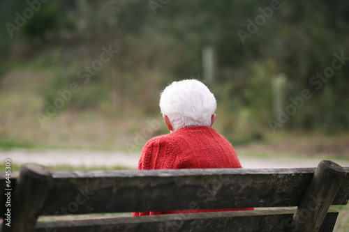 vieille dame avec les cheveux blancs assise sur un banc