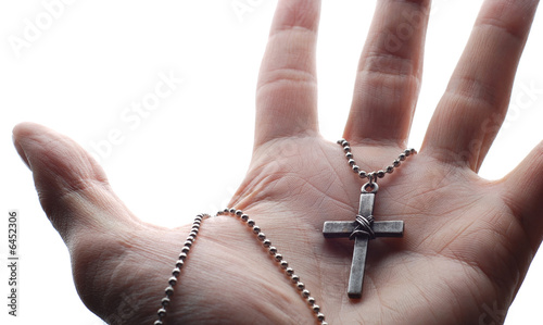 a hand is holding the cross in its palm