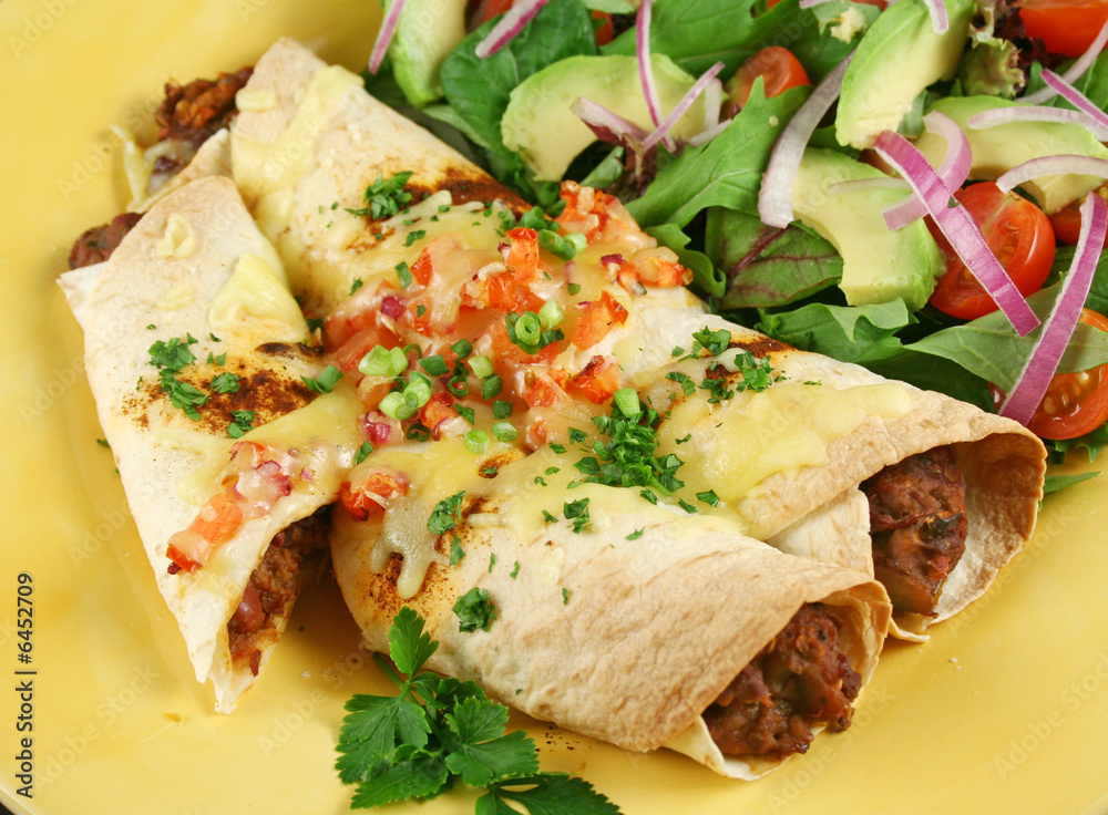 Beef and red kidney bean enchiladas with cheese and salad.