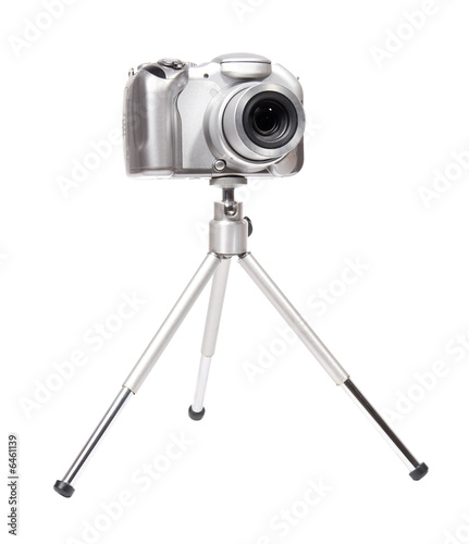 Modern digital camera with tripod. Isolated on white.