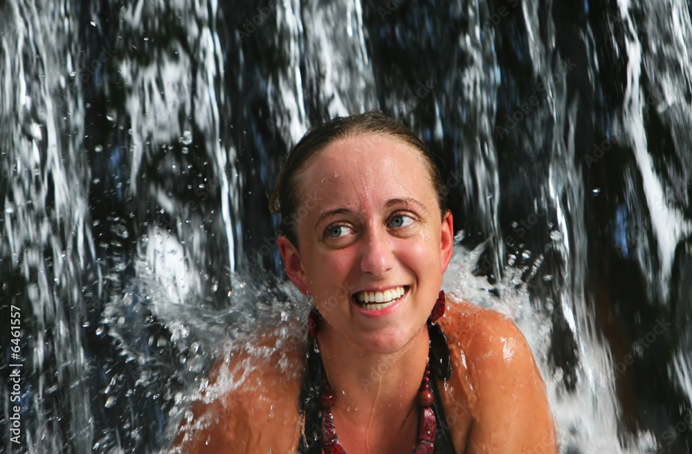 Fototapeta premium A young woman under a waterfall at a five star spa