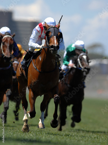 A jockey in action during on a horse during a race. photo