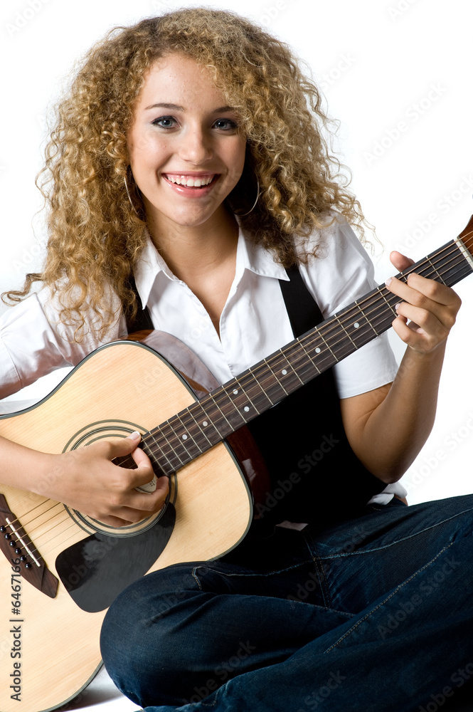 Fototapeta premium A pretty young woman playing acoustic guitar on white background