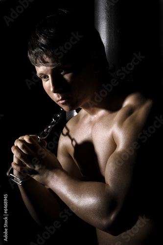 Muscular man with chain. Night in the conclusion
