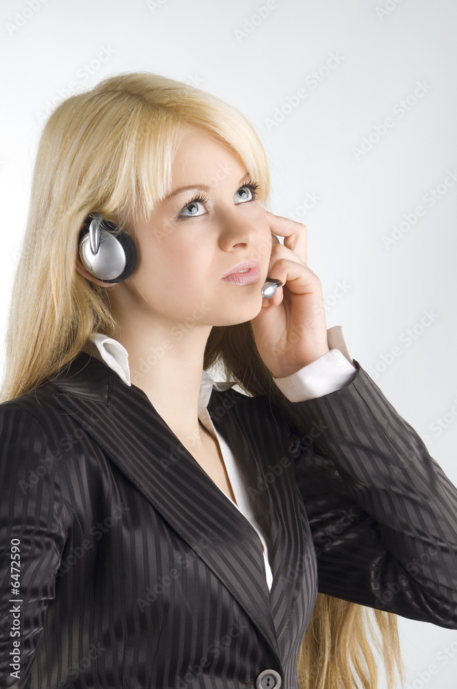 cute blond girl chatting with earphone and looking up cute blond girl chatting with earphone and looking up
