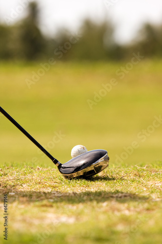 close up of driver golf club, and golf ball