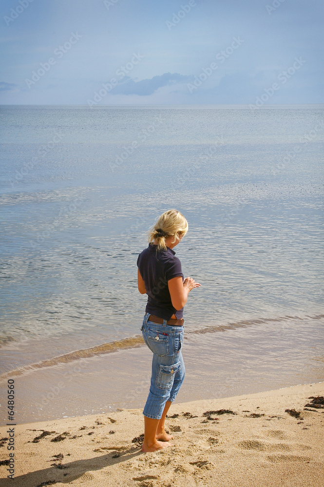 woman on the beach collecting stones