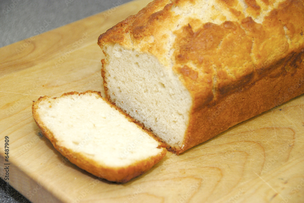 A slice of golden homemade bread on a wooden cutting board