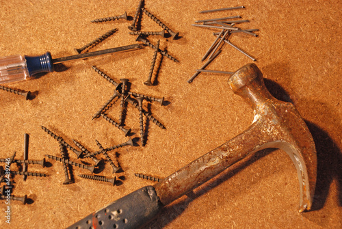 Hammer and Nails with Screws and Screwdriver on particle board